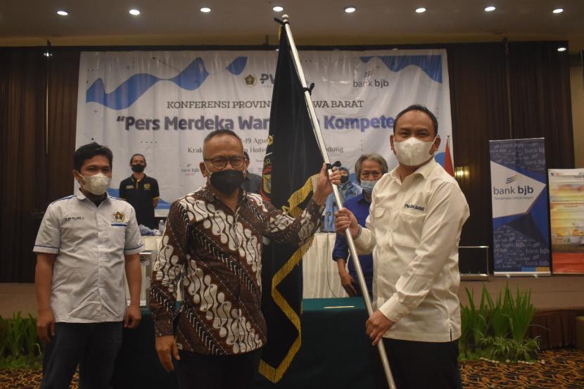 Ketua Umum PWI Atal S Depari (kiri) menyerahkan pataka kepada Ketua PWI Jabar periode 2021-2026 terpilih Hilman Hidayat dalam Konferensi Provinsi (Konferprov) PWI Jabar di Bandung, Rabu (18/8) malam.