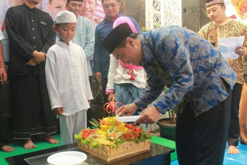 Ketua Yayasan Panti Yatim Indonesia Budiyono memotong tumpeng tanda peresmian asrama PYI ke-28 di Jalan Komodor Halim Perdana Kusuma No. 09, Jakarta Timur, Kamis (10/5).