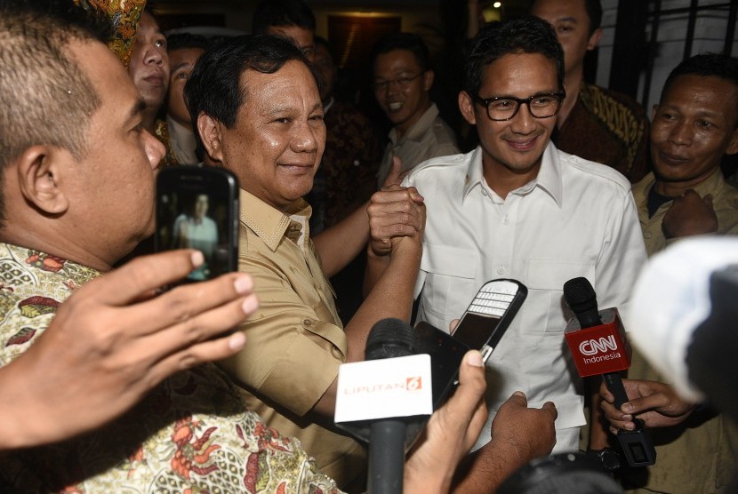 Ketum Partai Gerindra Prabowo Subianto (kedua kiri) bersama bakal calon gubernur DKI Jakarta Sandiaga Uno (kedua kanan) melakukan salam komando saat tiba di kediaman Prabowo Subianto, Jakarta, Kamis (22/9).