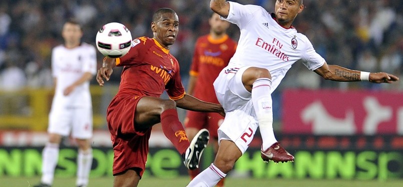 Kevin Prince Boateng (kanan), pemain AC Milan, berebut bola dengan bek Juan.