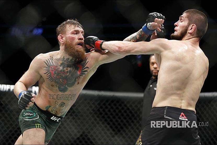 Khabib Nurmagomedov melepaskan pukulan ke arah wajah Conor McGregor pada laga UFC 229 di Las Vegas, Sabtu (8/10) waktu setempat.