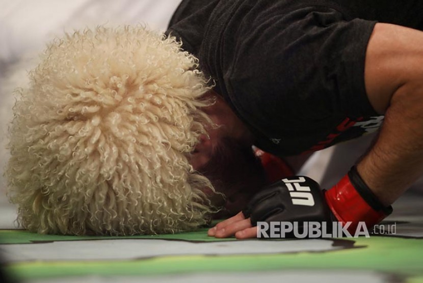 Khabib Nurmagomedov dengan mengenakan papakha melakukan sujud syukur setelah mengalahkan Dustin Poirier pada laga perebutan gelar Kelas Ringan UFC Lightweight di Abu Dhabi, Uni Emirat Arab, Ahad (8/9) dini hari.