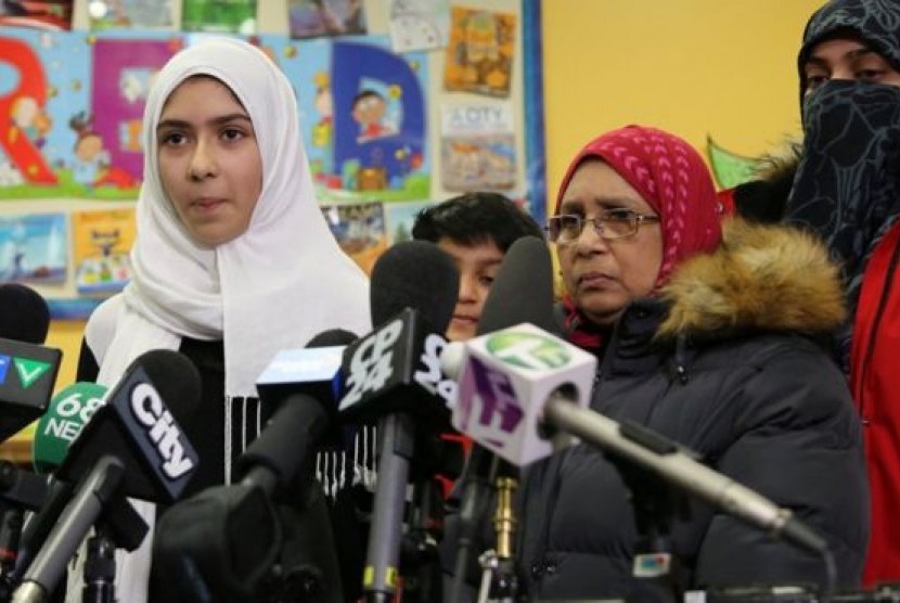 Khawlah Noman (kiri) berbicara kepada wartawan dengan didampingi ibunya di Pauline Johnson Junior Public School, Toronto, Kanada. Noman mengaku menjadi korban pengguntingan jilbab. 