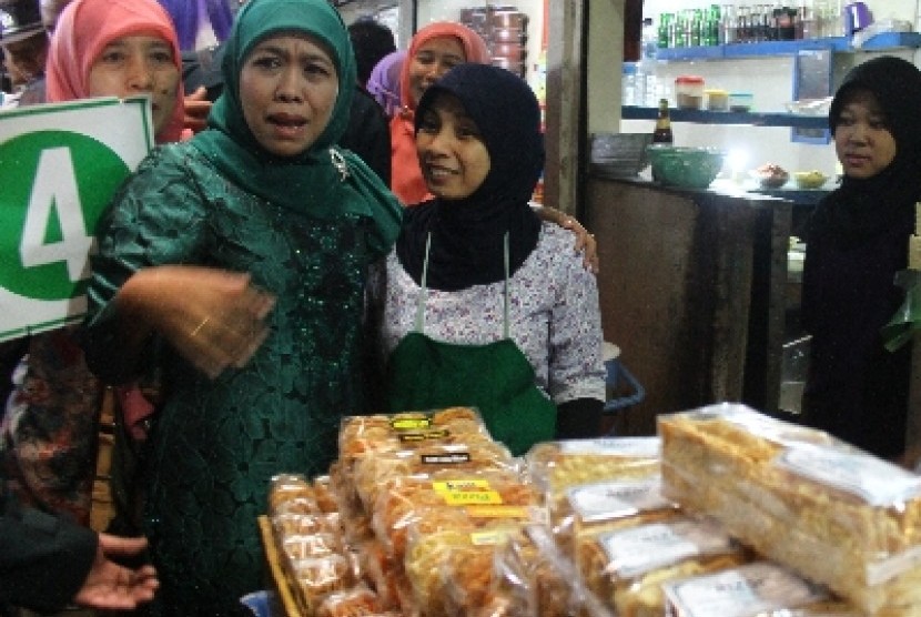 Khofifah Indar Parawangsa (kiri) berbincang-bincang dengan pedagang saat Kampanye di Pasarbesar, Malang, Jawa Timur, Ahad (18/8).