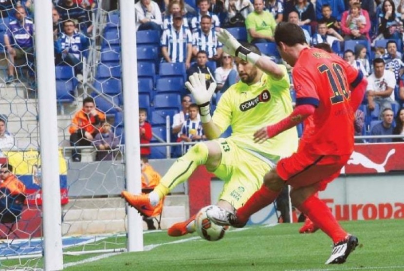 Kiko Casilla (kiri) saat berusaha mengadang tendangan Lionel Messi