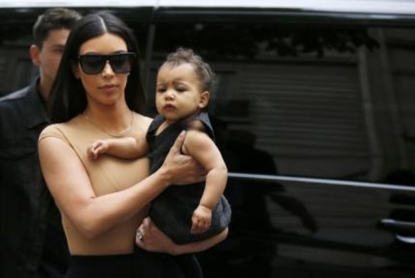 Kim Kardashian menggendong putrinya dengan Kanye West, North.