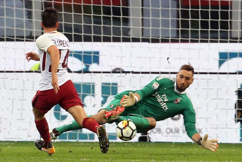 Kiper AC Milan Gianluigi Donnarumma (kanan) dan pemain AS Roma Alessandro Florenzi ketika kedua klub berhadapan pada lanjutan Liga Italia Serie A di Stadion San Siro, Milan, Italia, Ahad (1/10). 