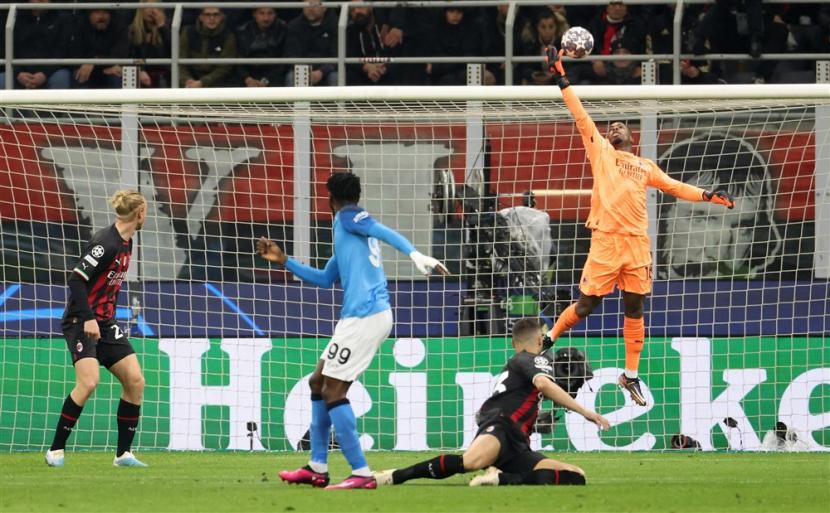 Kiper AC Milan Mike Maignan menyambar bola di udara untuk menjaga gawangnya dari kebobolan melawan Napoli pada laga leg pertama perempat final Liga Champions 2022/2023 di San Siro, Kamis (13/4/2023). 
