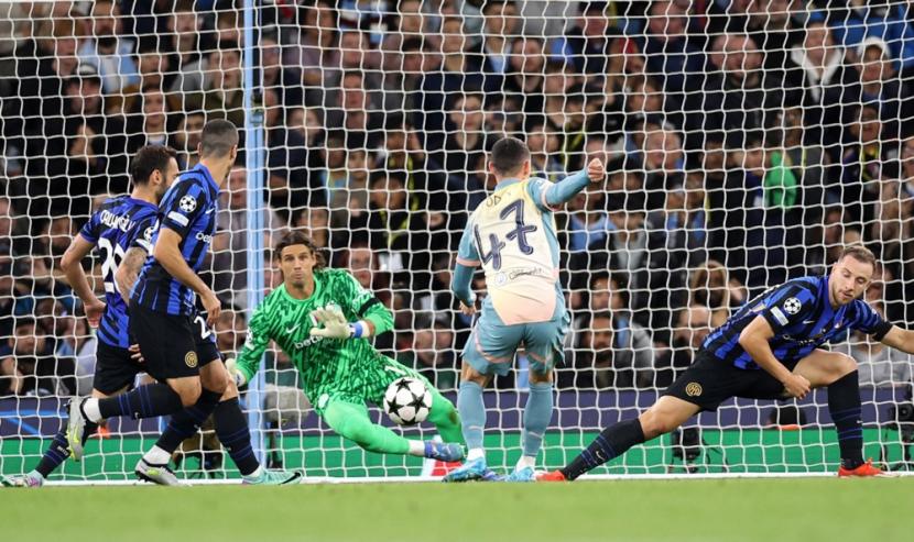 Kiper Inter Yann Sommer (tengah) melompat untuk melakukan penyelamatan dari tembakan ke gawang oleh gelandang serang Manchester City Phil Foden (tengah membelakangi) dalam pertandingan Liga Champions UEFA di Stadion Etihad, Manchester, Kamis (19/9/2024) dini hari WIB.