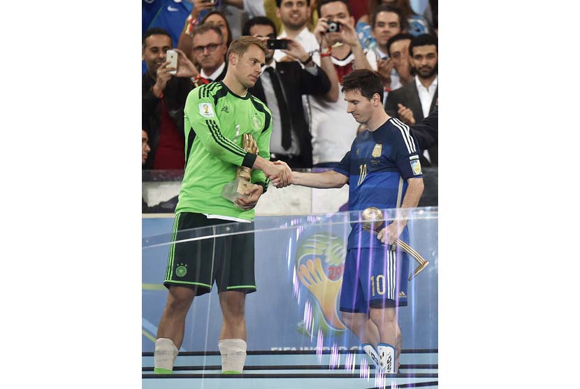 Kiper Jerman Manuel Neuer, kiri, pemenang penghargaan Golden Glove untuk kiper terbaik, berjabat tangan dengan Argentina Lionel Messi, pemenang penghargaan Golden Ball sebagai pemain top turnamen, Brasil, Minggu,Minggu(13/7). (AP/Martin Meissner)