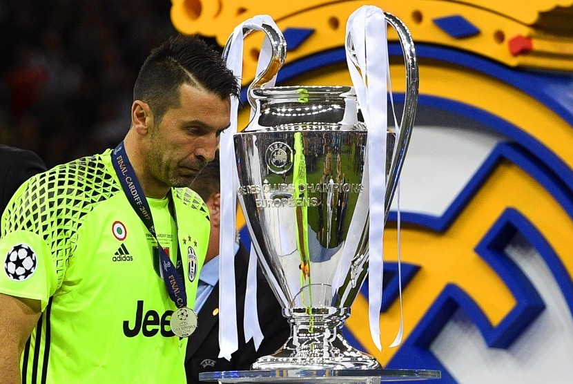 Kiper Juventus, Gianluigi Buffon berjalan di depan trofi Liga Champions seusai timnya kalah 1-4 dari Real Madrid pada laga final di Stadion Millennium, Cardiff, Ahad (4/6) dini hari WIB.