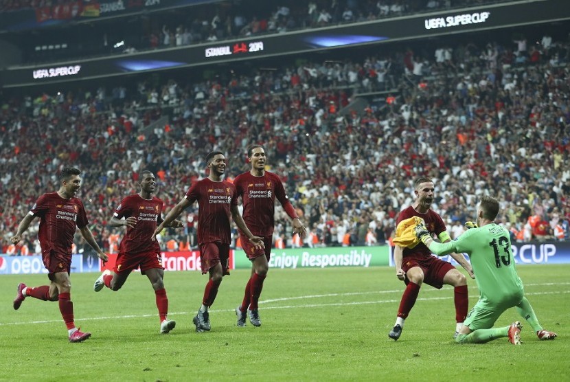 Kiper Liverpool Adrian merayakan kemenangan timnya bersama rekan-rekannya usai menggagalkan tendangan penalti pemain Chelsea Tammy Abraham di Piala Super Eropa, Kamis (15/8).