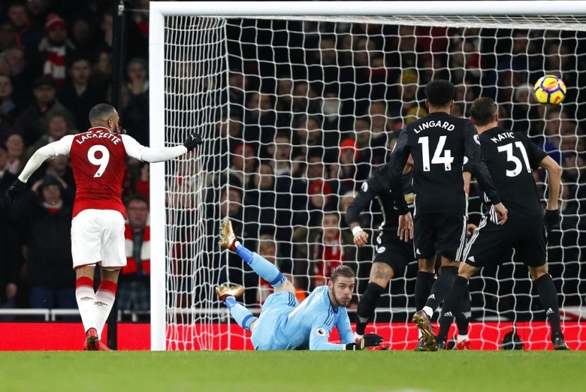 Kiper Manchester United, David De Gea (tengah) menggagalkan upaya striker Arsenal, Alexandre Lacazette mencetak gol pada laga Liga Primer Inggris, di Stadion Emirates, Sabtu (2/12).