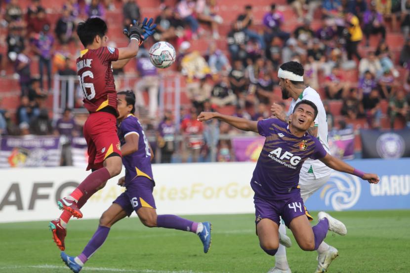 Kiper Persik Kediri Kartika Ajie (kiri) menangkap bola dari serangan pesepak bola PSS Sleman Tallysson Duarte (kanan) pada pertandingan Liga 1 di Stadion Brawijaya, Kota Kediri, Jawa Timur, Selasa (23/8/2022). PSS Sleman menang dengan skor 2-0. 