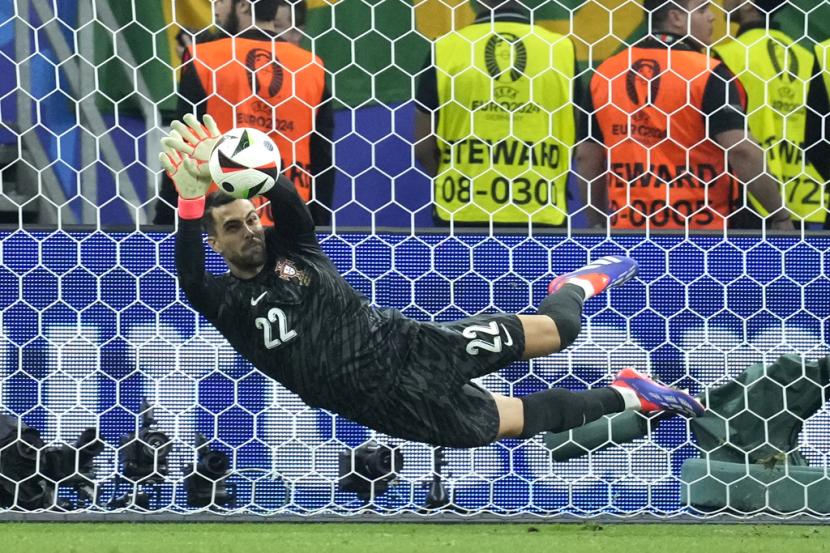 Kiper Portugal Diogo Costa mementahkan penalti Slovenia dalam babak adu penalti 16 besar Euro 2024. 