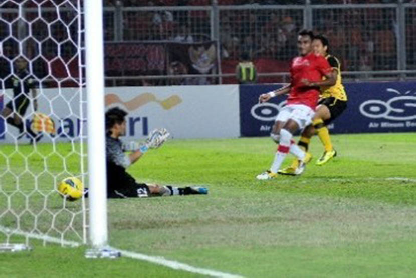 Kiper timnas Indonesia Andritany Ardhiyasa (kiri) tak kuasa menahan laju bola tendangan pesepakbola Malaysia Ibrahim Syahrul Azwari (kanan) yang berbuah gol saat pertandingan lanjutan babak kualifikasi Grup A SEA Games XXVI Indonesia di Stadion Utama Gelor