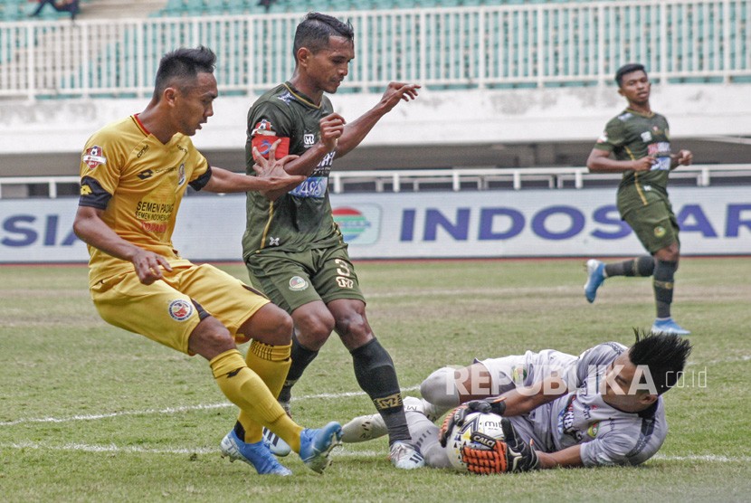 Kiper Tira Persikabo Angga Saputro (kanan) menangkap tendangan pesepak bola Semen Padang Dedi Hartono (kiri) pada lanjutan Liga 1 2019 di Stadion Pakansari, Cibinong, Bogor, Jawa Barat, Jumat (27/9/2019).