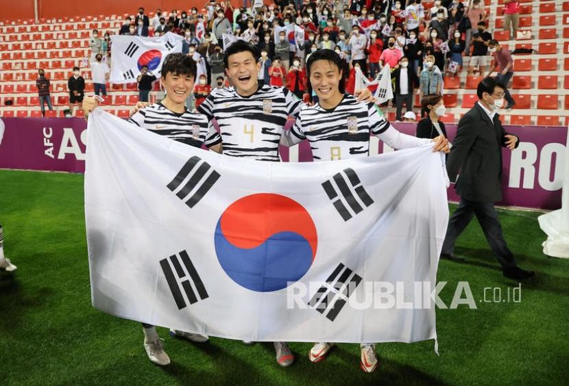  (kiri) Hwang In-beom, Kim Min-jae dan Baek Seung-ho dari Korea Selatan berpose dengan bendera nasional mereka setelah pertandingan final Piala Dunia FIFA 2022 Grup A pertandingan sepak bola kualifikasi Asia Korea Selatan vs Suriah di Rashid Stadium di Dubai, 01 Februari 2022.