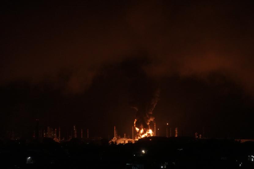 Kobaran api terlihat di tangki kilang PT Pertamina Internasional Unit Cilacap, Jawa Tengah, Sabtu (13/11). Setelah sempat padam, api sempat terlihat menyala kembali pada Ahad (14/11) pagi.