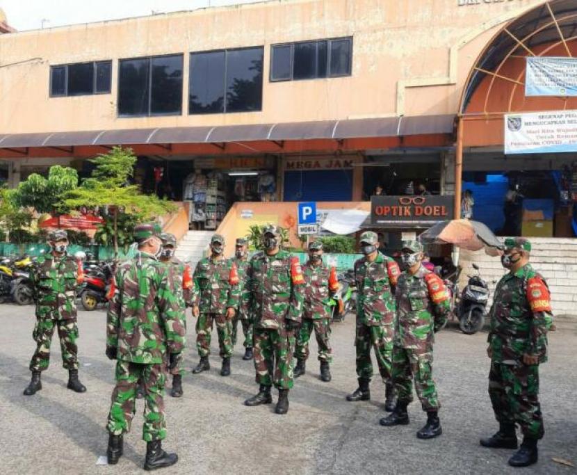 Komanda Koramil Sukmajaya Kapten Suyono sedang brifing anggota TNI untk mengawasi kerumunan orang di Pasar Agung, Sukmajaya, Kota Depok.