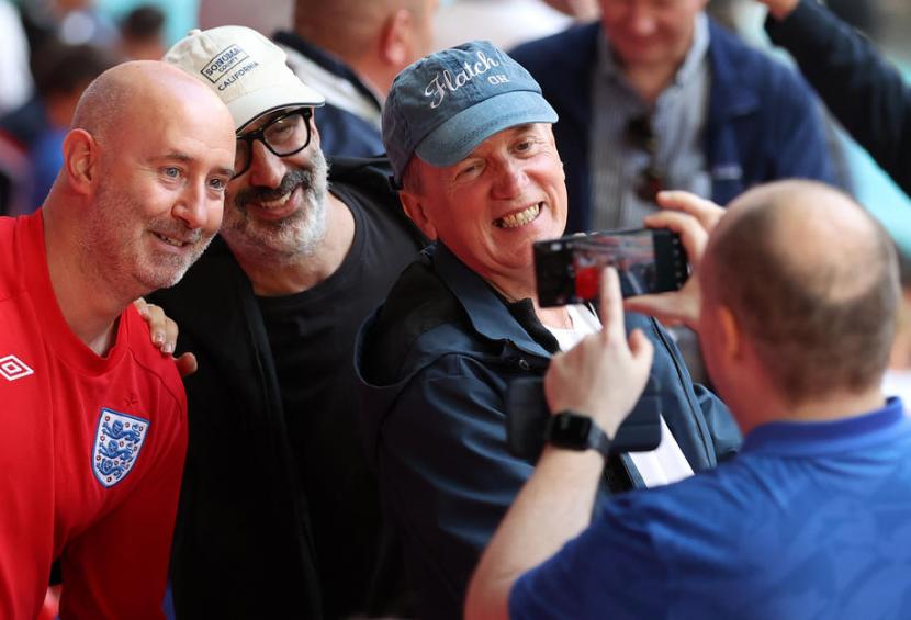  Komedian dan aktor Inggris Frank Skinner (kanan) dan komedian dan novelis Inggris David Baddiel (kedua dari kiri) berfoto dengan para penggemar sebelum dimulainya semifinal UEFA EURO 2020 antara Inggris dan Denmark di London, Inggris, 7 Juli. 