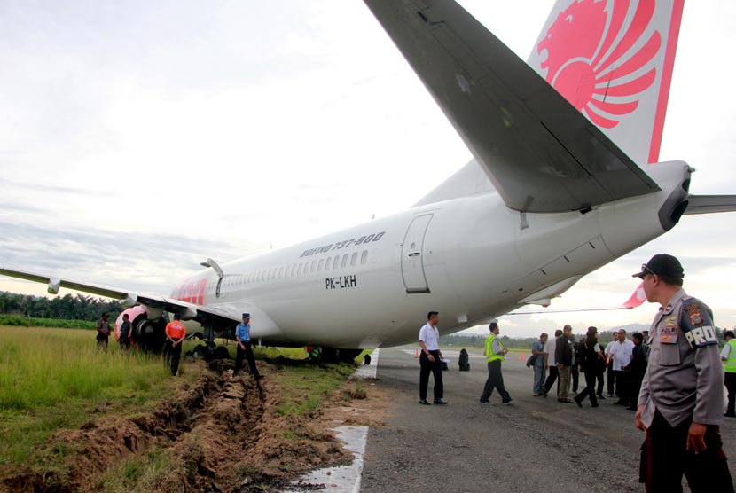   Komisi Nasional Keselamatan Transportasi (KNKT) memeriksa kondisi pesawat Lion Air di bandara Djalaludin, Gorontalo, Rabu (7/8).   (Antara/Adiwinata Solihin)