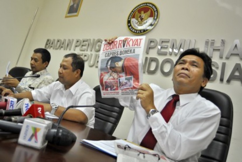 Komisioner Bawaslu Nelson Simanjuntak (kanan) dan Nasrullah (tengah) menunjukkan tabloid Obor Rakyat yang diduga melanggar aturan kampanye pilpres di Kantor Badan Pengawas Pemilu, Jakarta, Rabu (4/6). 