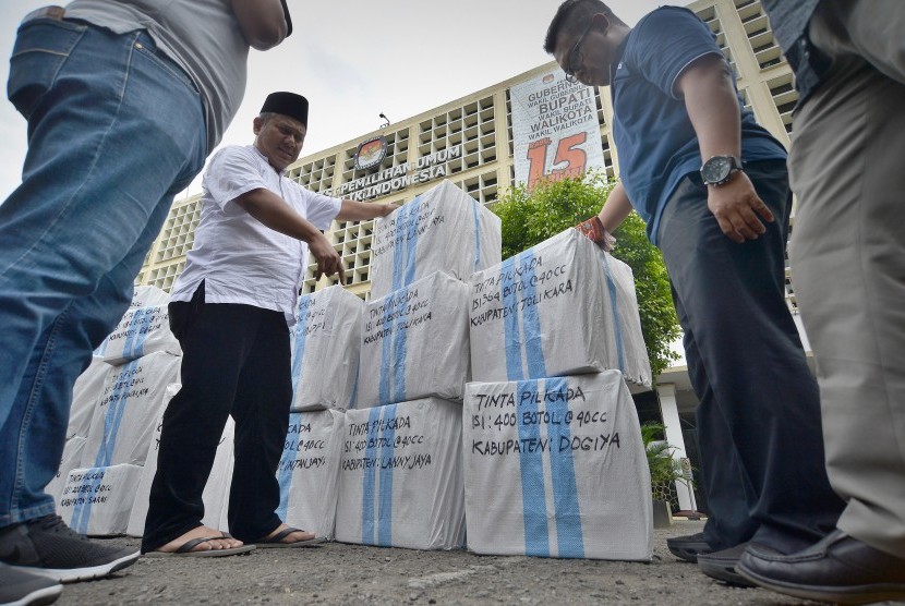 Komisioner KPU Arief Budiman (kiri) memeriksa paket logistik tinta Pilkada yang akan dikirim ke Papua, Jakarta, Jumat (13/1).