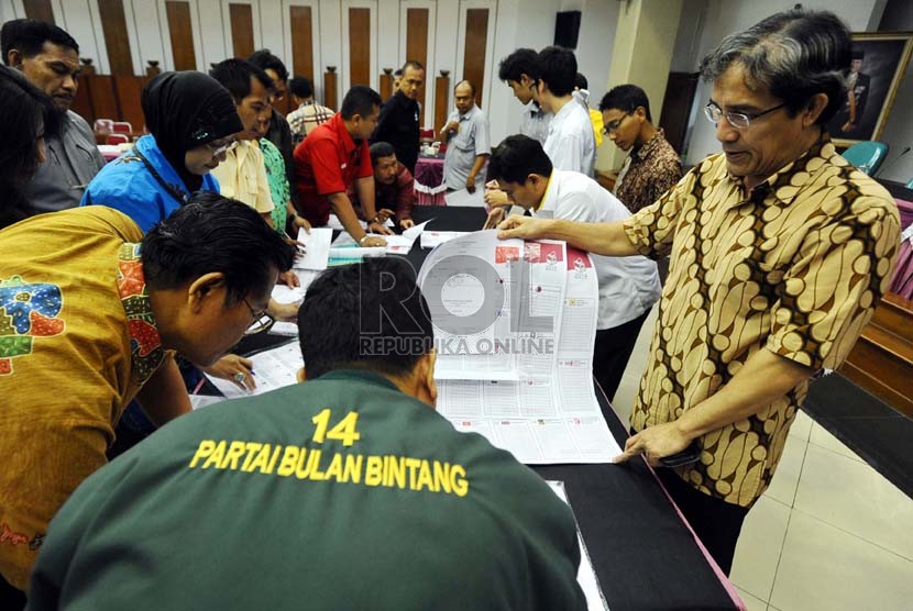Komisioner KPU Hadar Gumay (kanan) merapihkan surat suara saat rapat koordinasi dengan perwakilan partai politik di kantor Komisi Pemilihan Umum (KPU), Jakarta, Senin (23/12). (Republika/Tahta Aidilla)