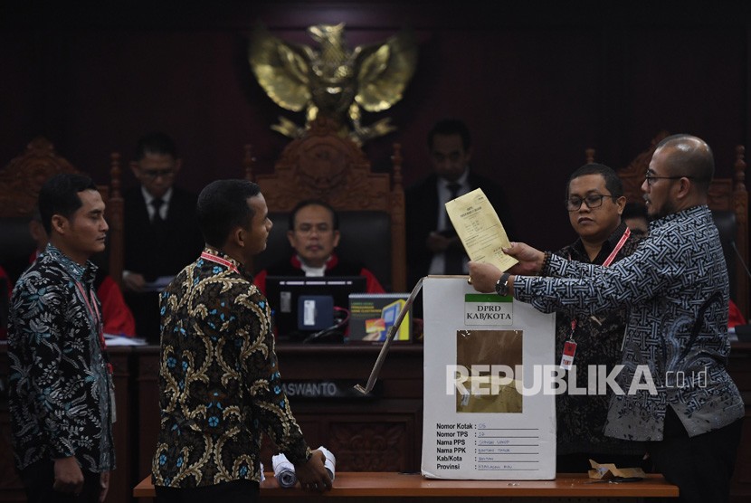 Komisioner KPU Hasyim Asyari (kanan) membuka kotak suara saat sidang lanjutan Perselisihan Hasil Pemilihan Umum (PHPU) Pileg 2019 di Mahkamah Konstitusi, Jakarta, Kamis (25/7/2019). 