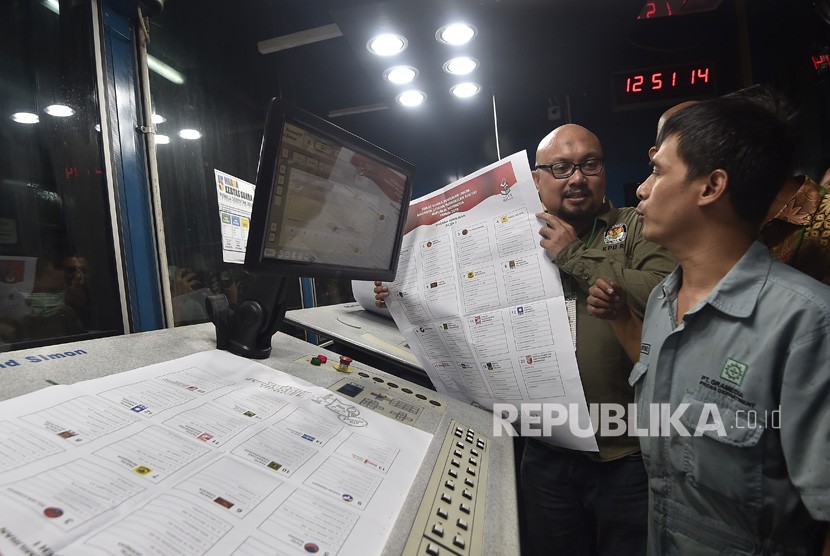 Komisioner KPU Ilham Saputra (kiri) melakukan pemeriksaan kualitas warna surat suara legislatif saat proses pencetakan, di Jakarta, Ahad (20/1/2019). 