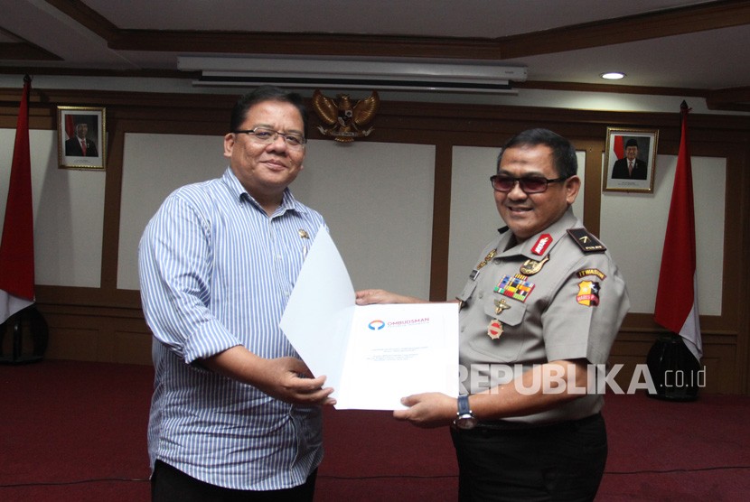 Komisioner Ombudsman Adrianus Meliala (kiri) menyerahkan surat laporan hasil pemerksaan kepada Itwasum Wilayah (Irwil) IV Mabes Polri Brigjen Pol Endang Surya Darma (kanan) saat penyerahan surat pemeriksaan Laporan Akhir Hasil Pemeriksaan (LAHP) di Kantor Ombudsman, Jakarta, Selasa (13/2). 