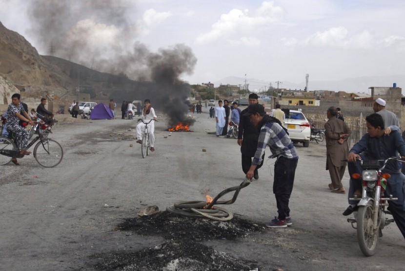 Komunitas Hazara membakar ban untuk memblokir jalan utama dalam protes mengecam bom bunuh diri di pasar di Quetta, Pakistan, Sabtu (13/4).