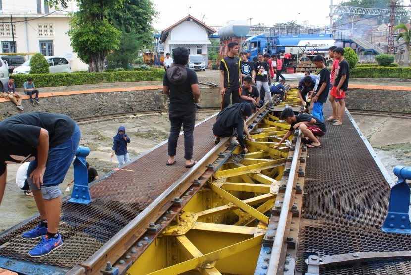 Komunitas pecinta kereta mencuci turntable kereta yang umurnya sudah 100 tahun di Dipo Jatinegara, Ahad (29/5).