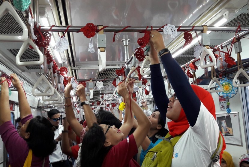 Komunitas RajutKejut menggelar yarn bombing dengan membuat rajutan merah putih di gerbong ketiga KRL Depok-Jakarta Kota, Rabu (17/8).