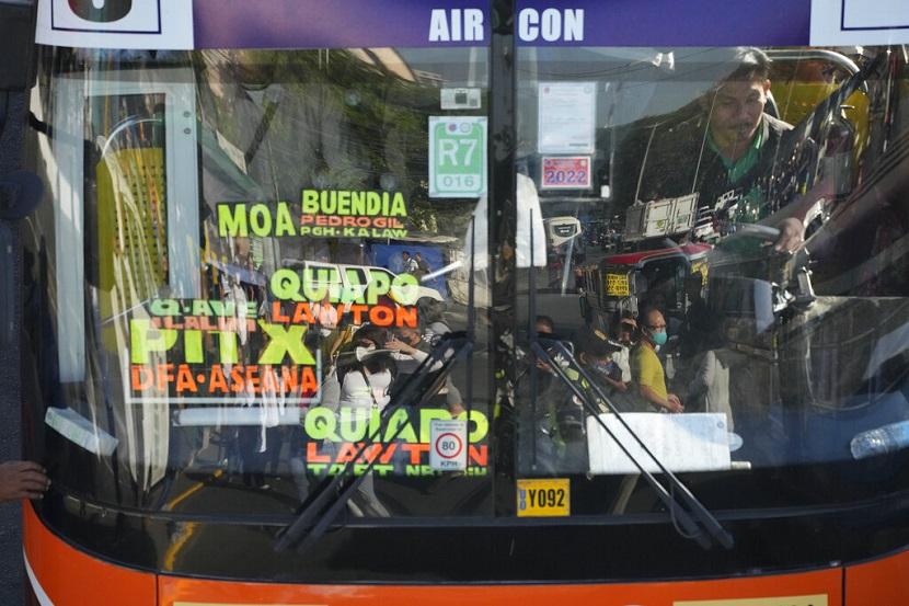 Komuter tercermin di kaca depan bus saat mereka menunggu untuk naik selama pemogokan transportasi di Quezon City, Filipina pada hari Senin, 6 Maret 2023. Kelompok -kelompok transportasi Filipina meluncurkan pemogokan nasional pada hari Senin untuk memprotes program pemerintah yang ditakuti oleh para pengemudi yang ditakuti oleh para pengemudi pemerintah akan dihapuskan keluar Jeepneys tradisional, yang telah menjadi ikon budaya, dan kendaraan transportasi umum lainnya yang sudah tua. 