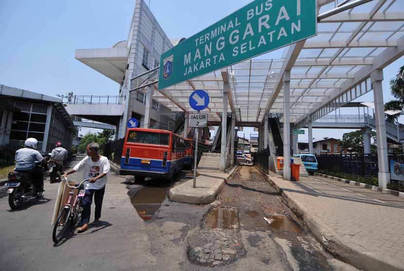 Kondisi aspal perlintasan yang rusak dan tergenang air di Terminal Manggarai, Jakarta Selatan, Selasa (23/9). (Republika/Rakhmawaty La'lang).