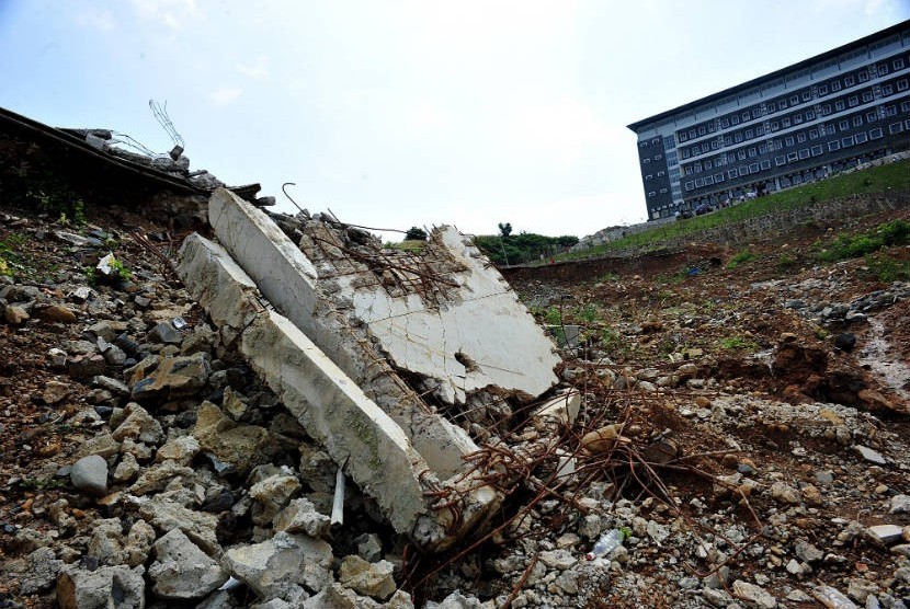  Kondisi bangunan gardu istrik yang tinggal puing dengan latar belakang wisma atlet putra di Bukit Hambalang, Bogor, Jawa Barat, Rabu (30/5). (Edwin Dwi Putranto/Republika)