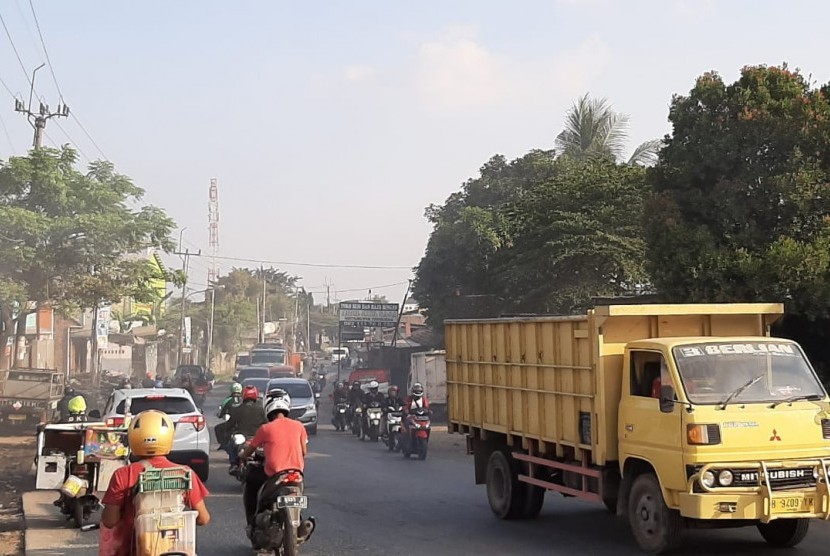 Kondisi Jalan Cikarang-Cibarusah di Kabupaten Bekasi yang kerap macet dan rawan kecelakaan. Jalan Cikarang-Cibarusah Ganti Nama Jadi Jalan KH Raden Ma'mun Nawawi