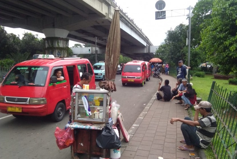 Kondisi lalu lintas di kolong flyover pasar rebo dipenuhi oleg angkot dan PKL