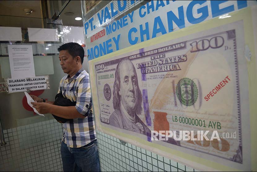 Konsumen menukarkan mata uang asing di jasa penukaran uang asing Valuta Artha Mas ITC Kuningan, Jakarta,Kamis (26/4). Nilai tukar rupiah rebound pada perdagangan Kamis (26/4), Rupiah di tutup menguat 0,22% ke posisi Rp 13.891 per dolar AS, setelah dibuka di level Rp 13.919 per dolar AS.