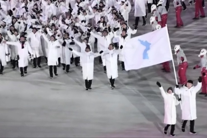Kontingan Korea Selatan dan Korea Utara jalan bersama memegang satu bendera di pembukaan Olimpiade musim dingin.