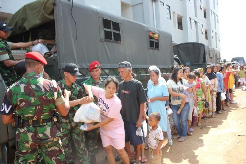 Anggota Kopassus membagikan paket sembako untuk korban banjir di rumah susun Penjaringan Muara Baru ,Jakarta Utara,Kamis (7/2).  (dok. Penerangan Kopassus)