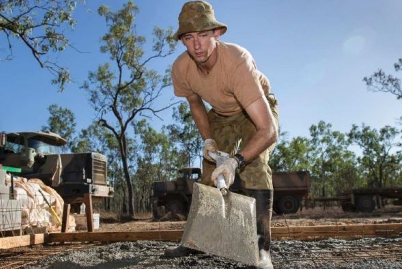 Kopral Jason Neumann sedang membuat lantai semen sebagai bagian dari Army Aboriginal Community Assistance Program (AACAP) di Queensland utara. 
