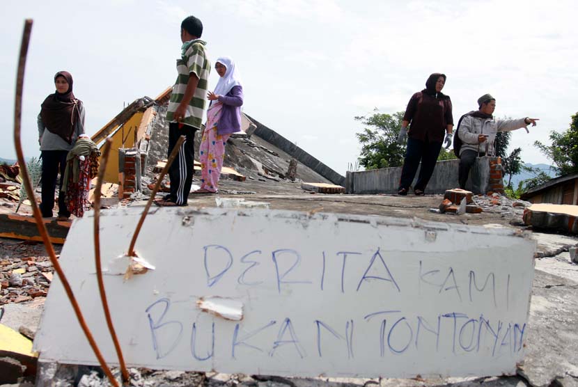   Korban Gempa berdiri diantara puing-puing bangunan rumahnya yang rusak akibat gempa bumi di Desa Blang Mancung Bawah, Ketol, Aceh Tengah, Aceh, Jumat (5/7).    (Antara/Irwansyah Putra)
