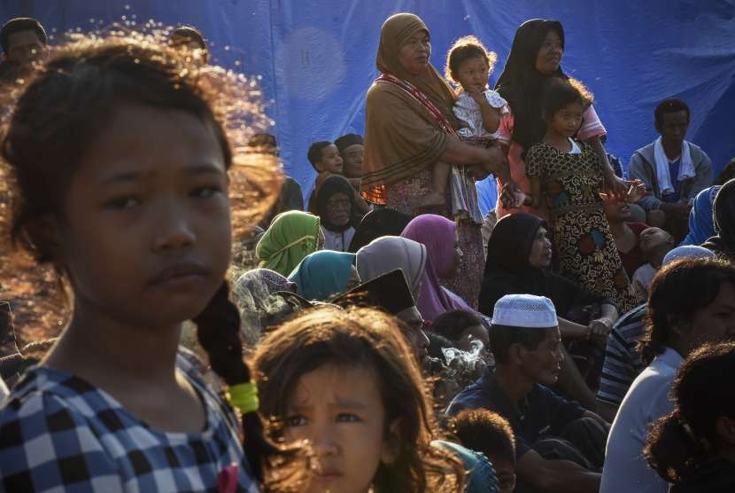 Korban gempa menunggu kedatangan Presiden Joko Widodo di Posko Pengungsian Dusun Karang Subagan, Desa Pemenang Barat, Pemenang, Lombok Utara, NTB, Selasa (14/8). 