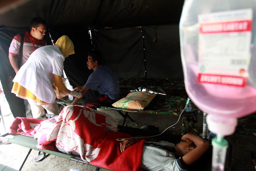  Korban Gempa yang tertimpa bangunan mendapat perawatan medis di Posko Kesehatan Desa Blang Mancung, Ketol, Aceh Tengah, Aceh, Jumat (5/7).    (Antara/Irwansyah Putra)