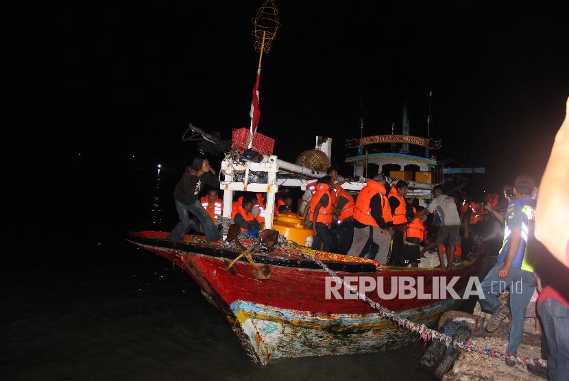 Korban KM Santika Nusantara yang terbakar turun dari perahu nelayan yang membawanya di Pelabuhan Kalianget, Sumenep, Jawa Timur. Jumat (23/8/2019). Sedikitnya 80 korban dievakuasi ke Kabupaten Sumenep dan sebagian ke Surabaya. 
