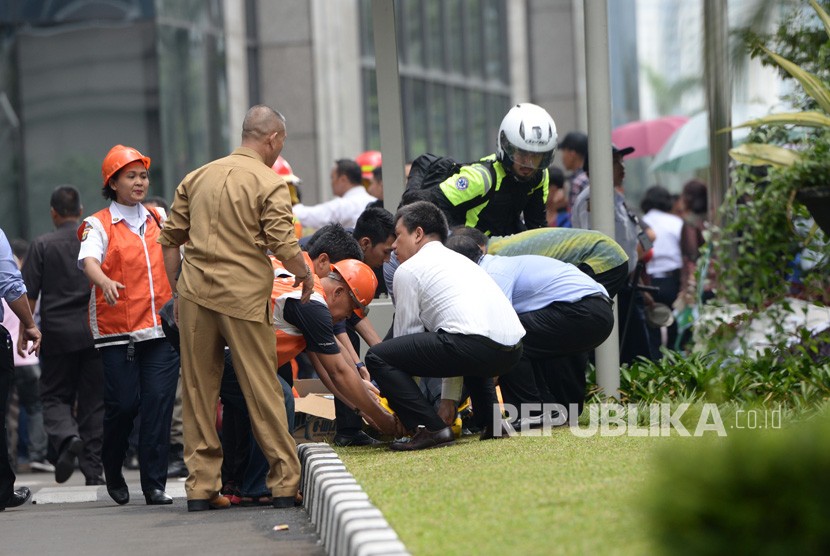 Korban menunggu ambulan pasca ambruknya selasar di tower 2 Bursa Efek Indonesia, Jakarta, Senin (15/1). Jumlah korban sementara 75 orang dan sudah dirujuk ke rumah sakit. Penyebab ambruknya selasar masih belum diketahui, menunggu investigasi