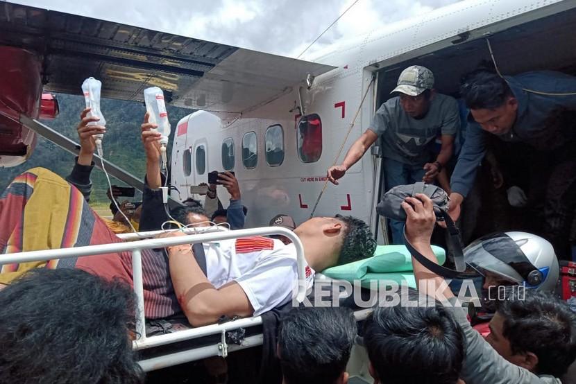 Korban penembakan KKB ditandu menaiki pesawat saat evakuasi di Intan Jaya, Papua, Senin (14/9). Dua tukang ojek ditembak di Sugapa, Kabupaten Intan Jaya dan saat ini telah dibawa ke Timika untuk menjalani perawatan. 
